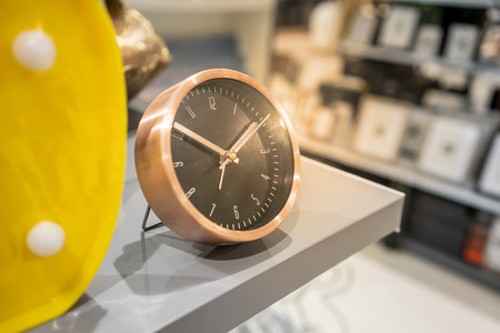 Modern wood and black clock on grey shelf for decorationの写真素材