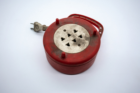 Dirty red and white power extension lead with multiple sockets isolated on white background.の写真素材