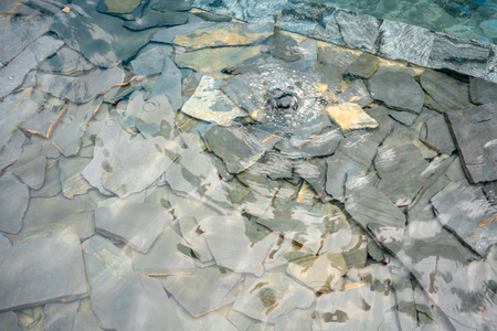 Decorative fountain water on modern rock stone crack pieces. Ladnscape design detail.の写真素材