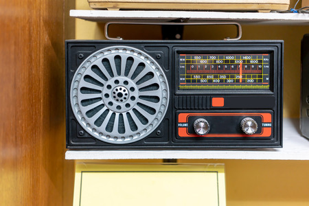 Vintage retro radio on wooden shelf. Retro technology and music concept.の写真素材