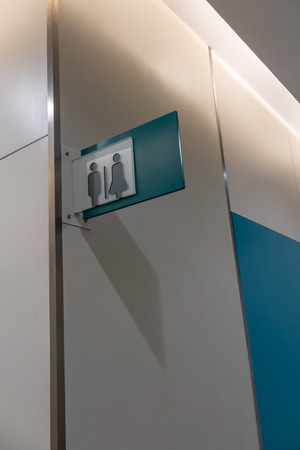 Modern restroom sign or toilet sign with man and woman icon set symbol on white concrete wall background, modern, hygiene and clean restroom conceptの写真素材