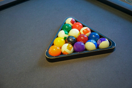 Pool billiard balls in a wooden rack on black background - commonly used starting position.の写真素材