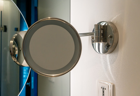 Circle shape mirror with LED light mounth on white wall in restroom. Round mirror in the bathroom.の写真素材
