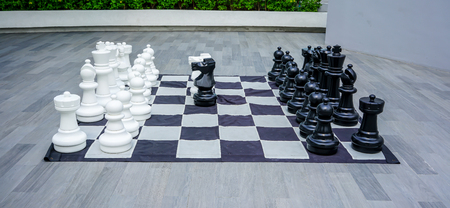 Super big size of black and white chess game pieces, figures on chess board for outdoor decoration.