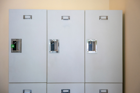 Close up on lockers in gym against white background. A row of white metal school lockers with keys.の写真素材