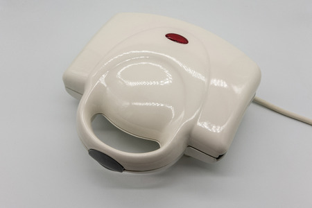 White grossy toaster with red light isolated on white background.