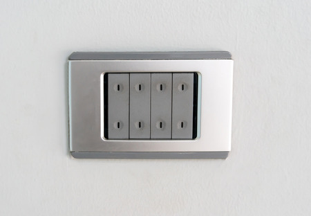 An electric light switch against white wall backgroundの写真素材