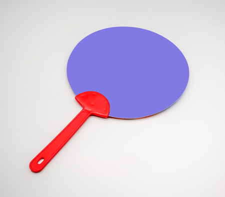 Hand holding red and blue plastic fan isolated on white background.の写真素材