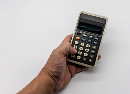 Hand holding the vintage calculator isolated on white background.の写真素材
