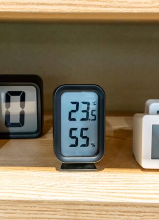 Black pocket digital temperature on wooden shelf for decorationの写真素材