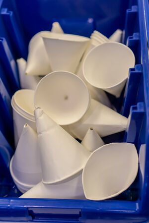 White paper cone cups in blue box. Material for kid project.