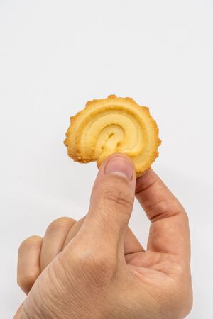 Hand holding the homemade cookie isolated on white background.の写真素材