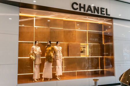 Chanel shop at Emquatier, Bangkok, Thailand, July 7, 2019 : Luxury and fashionable brand window display. New collection of Gold clothings and accessories showcase at flagship store. Perspective view.のeditorial素材