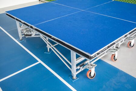 Foldable stage with blue floor with metal structure and orange wheels.