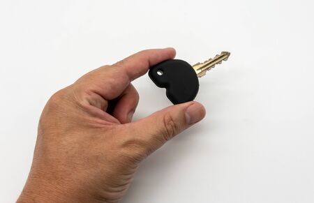 Hand holding the black silicone for car or motocycle key isolated on white background