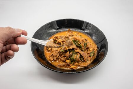 Thai red chili curry stir fried with beef shank, basil, and black pepper. One of most popular home cooking spicy menu isolated on white backgroundの写真素材