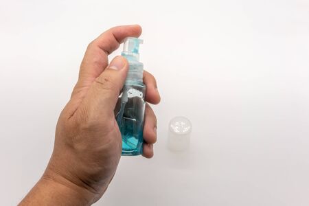 Hand holding small pocket blue gel bottle isolated on white background.の写真素材