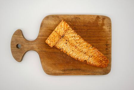 Spicy dried and rolled squid on wooden cutting board isolated on white background. Fine chili seasoning seafood snacks.の写真素材