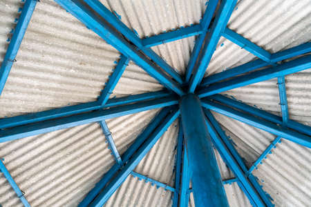 Blue metal roof structure with grey roof tile on top.の写真素材