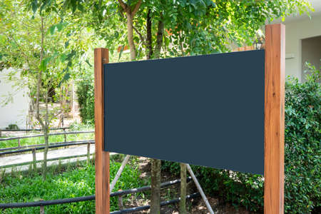 Black board mockup with wood poles structure against nature background.の写真素材