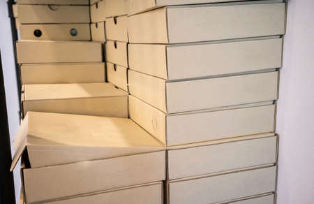 Stack of recycle papaer square boxes on white wall background.