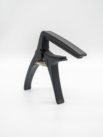 Matte black capo for acoustic and classical guitar isolated on white background.の写真素材