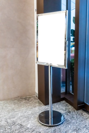 blank indoor poster or information board with metal frame stands at a walkway for advertising.の写真素材