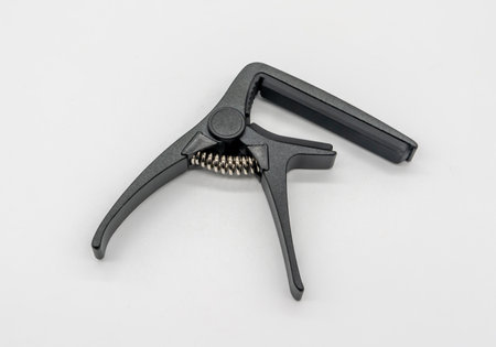 Matte black capo for acoustic and classical guitar isolated on white background.の写真素材
