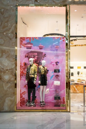 Versace shop display at Icon Siam, Bangkok, Thailand, Nov 28, 2020 : Luxury fashionable clothing and shoes visual merchandising and window shopping in Gold Christmas greeting.のeditorial素材