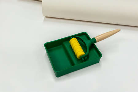 Yellow and green brush roller paint tray isolated on white background. Kid toy.