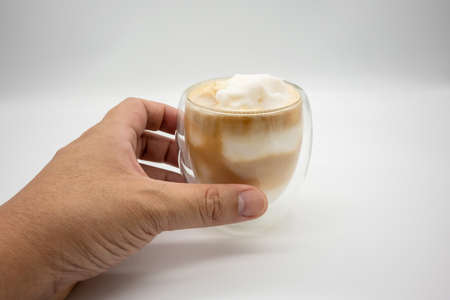 Hand holding coconut blend coffee in double wall glass isolated on white background.の写真素材