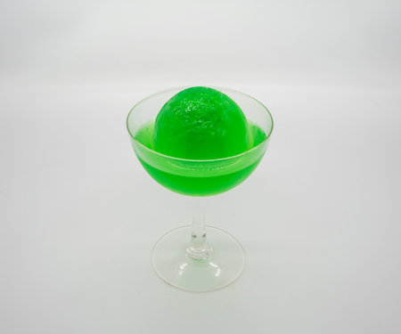 Green Apple Soda ice ball in clear cocktail glass isolated on white background.の写真素材