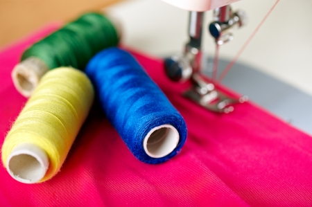 Close up of threads on fabric and sewing machine. Shalow DOF. Selective focus. Focus on blue...