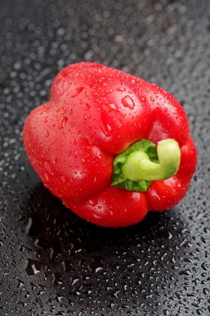 Red bell pepper on black table after rainの写真素材