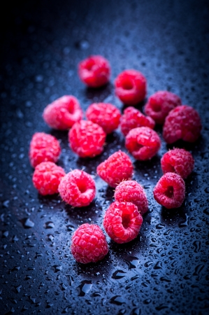 Fresh raspberries after rain on blueの写真素材