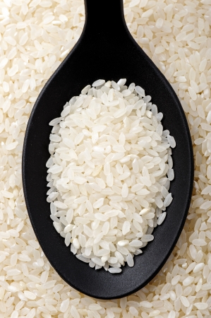 Top view of black spoon full of calrose riceの写真素材