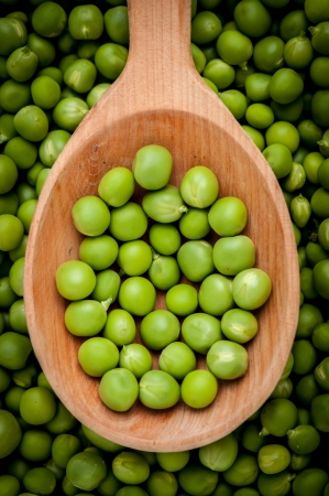 Fresh peas on wooden spoonの写真素材