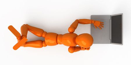 Orange mannequin with laptopの写真素材