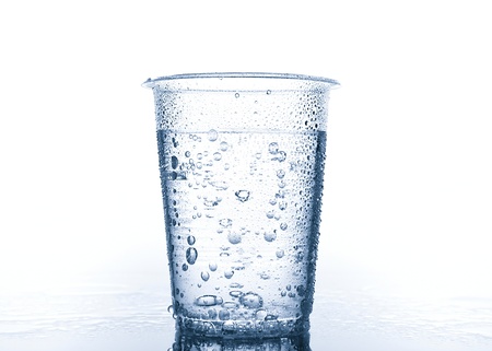 Plastic cup with water on wet surfaceの写真素材