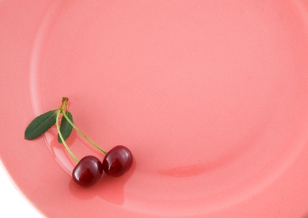 Two cherries with stem on pink plate.For inspector:There is not a noise artefacts. It is structure of material under glaze. Thank You.の写真素材