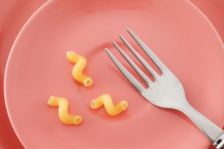 Fork and three piece of macaroni on the pink ceramic plate. の写真素材