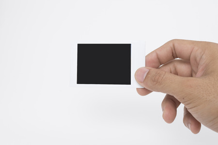 Hand holding instant film isolated on white backgroundの写真素材