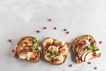 Peanut butter sandwiches with apple banana and pomegranate background. Food background, copy space,...