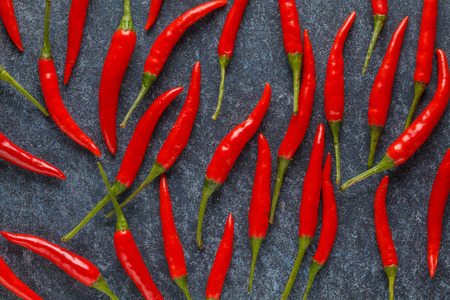 Little red chili peppers on a blue background. Vegetable background.