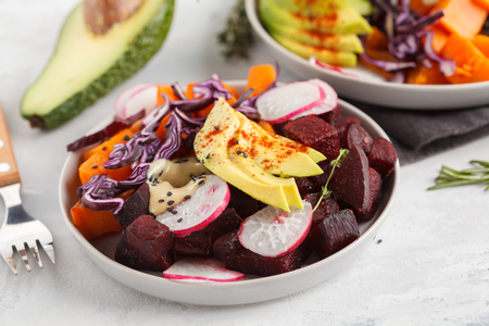 Bright vegetarian salad of baked beets, sweet potato and avocado. Healthy vegan food concept.の写真素材