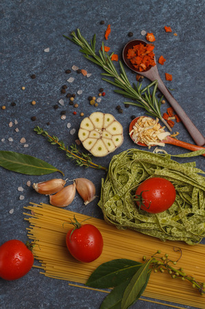 Selection of spices, pasta and greens. Ingredients for cooking pasta. Dark background, top view, copy space.の写真素材