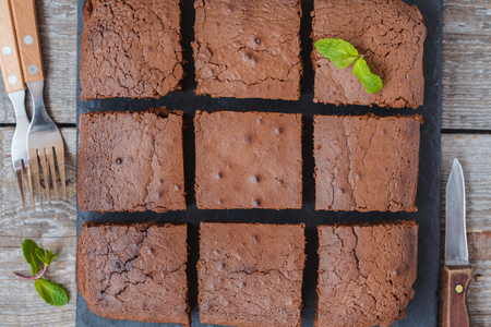 Cut pieces of chocolate brownie on a slate board, top view.の写真素材
