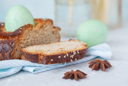 Traditional Greek Easter bread - tsoureki, sliced in Easter decoration with painted eggs and flowers. Easter Festival concept.の写真素材