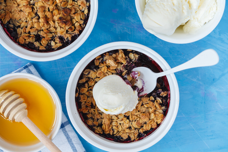 Winter breakfast with berry crumble and tea with lemon. Blue background.の写真素材