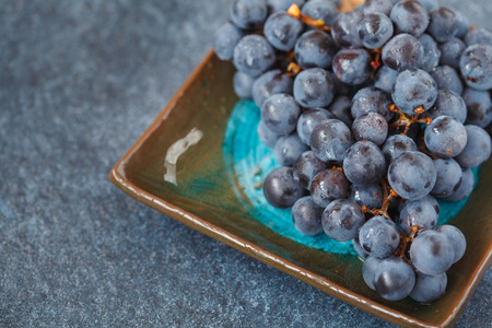 Red wine grape on a dark plate. Blue grapes, dark grapesの写真素材